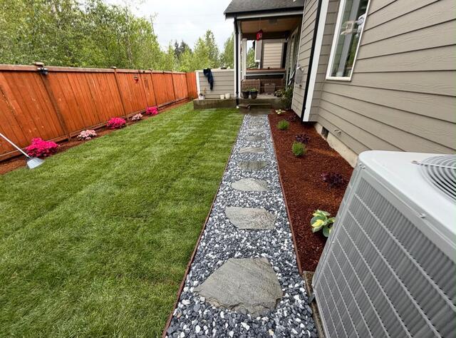 Fresh lawn and gravel path with stepping stones leading to a porch