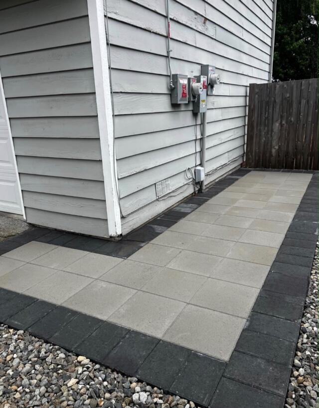 Gray paver patio installed beside a house